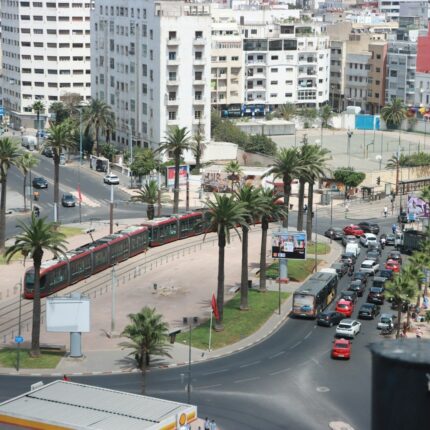 A city street filled with lots of traffic next to tall buildings