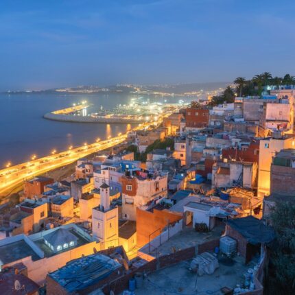 aerial view of city near body of water during night time